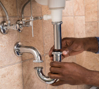 Close-up Of Male Plumber's Hand Fixing Sink In Bathroom